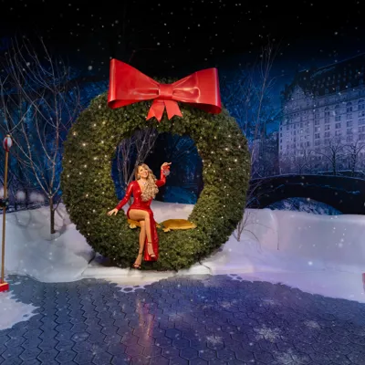 Mariah Carey wax figure at Madame Tussauds New York, flanked by nutcracker figures on each side.