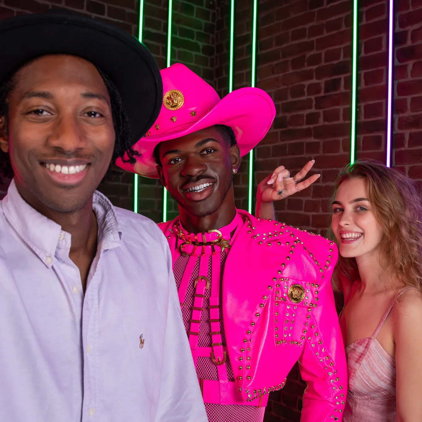 Two people talking a selfie with the figure of Lil Nas X