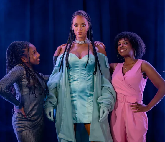 A mother and daughter stood next to a figure of Rihanna