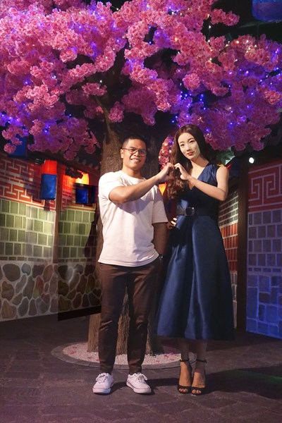 A visitor of Madame Tussauds encountered korean actress Bae Suzy's wax figure and took a picture of him completing a korean heart sign with the figure. 