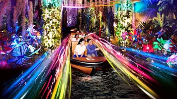 Spirit of Singapore boat ride at Madame Tussauds Singapore - A boat with people sitting inside, passing by figures of iconic Singapore landmarks in a colorful and immersive environment