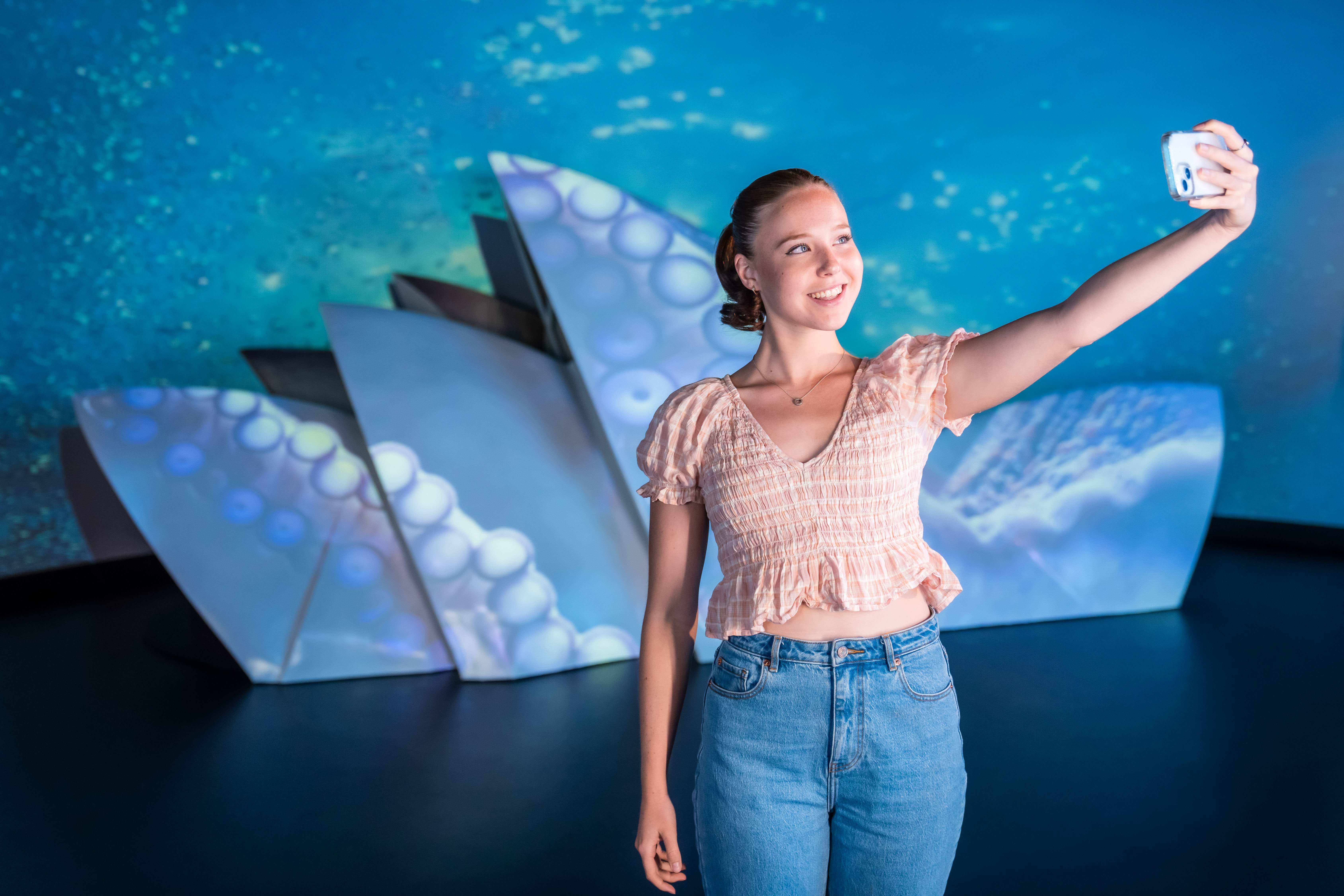 Madame Tussauds Sydney Guest Smiling Taking A Selfie In Front Of The Sydney Opera House