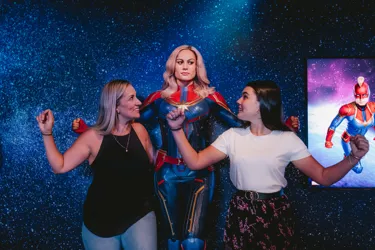 Guests posing with Captain Marvel at Madame Tussauds